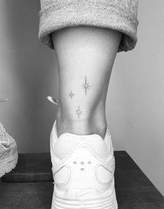 a woman's foot with a small star tattoo on her left side ribcage