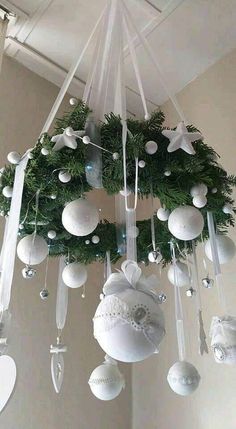 a christmas wreath hanging from the ceiling with baubles and ornaments attached to it