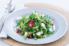 a white plate topped with salad next to a fork