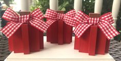 three red boxes with bows on them sitting on a table