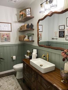 a bathroom with a sink, mirror and shelves on the wall next to the toilet