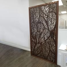 a room divider in an office with wood flooring and white walls behind it