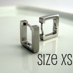 two silver square rings sitting on top of a white surface with the words size xs below them