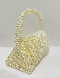 beautiful white pearl purse to elevate your style. fits your phone Rectangular Cream Evening Bag As Gift, Rectangular Cream Evening Bag Gift, Cream Evening Bag With Pearl Handle, Pearl Embellished Clutch, Cream Rectangular Evening Bag, White Evening Bag With Pearl Handle As A Gift, Elegant Handheld Beaded Evening Bag, Elegant Cream Bag With Pearl Handle, Pearl White Beaded Shoulder Bag For Party