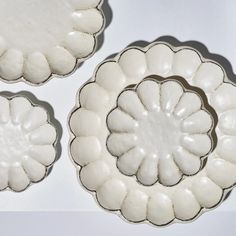 three white dishes sitting on top of a table