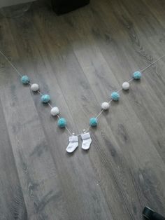 a baby's pacifier necklace with blue and white pom - poms