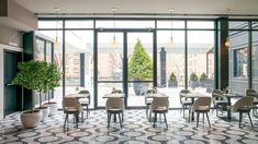 an empty restaurant with tables and chairs in front of large glass doors that look out onto the street