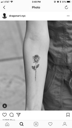 a black and white photo of a person with a rose tattoo on their arm