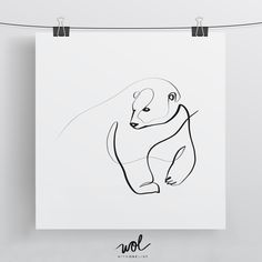 a black and white drawing of a bear on a paper hanging from a clothes line