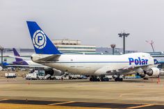 an airplane that is sitting on the tarmac with other planes in the back ground