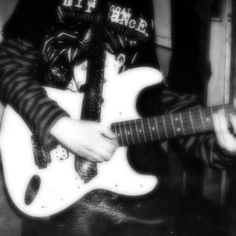 black and white photograph of a person playing an electric guitar