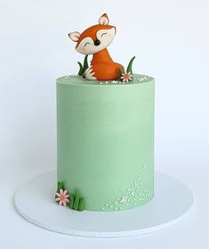 there is a green cake with a fox on top