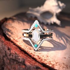 a diamond ring sitting on top of a piece of wood next to a sea urchin