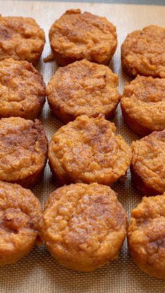 a bunch of muffins sitting on top of a piece of brown parchment paper