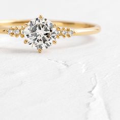 a yellow gold engagement ring with an oval cut diamond surrounded by small round diamonds on the band