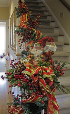 a decorated christmas tree with santa clause on it's head and red, green and yellow ribbons