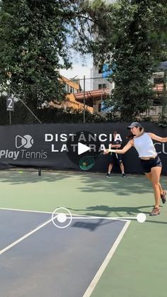 a woman swinging a tennis racquet on top of a tennis court