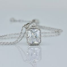 "Classically elegant and sophisticated! Emilia cz crystal bridal necklace made in a radiant cut with a frame of tiny cz crystals for a beautiful sparkling accessory that will suit your dress, whatever style. The 18K rhodium setting has delicate carving around the sides so your necklace is pretty from all aspects! All components are rhodium plated sterling silver. Nickel free. Rhodium plating helps prevent issues with silver allergies. Measurements: Chain - With extender measures 16\" - 18\" (41 Luxury Square Pendant Solitaire Necklace For Gift, Elegant Baguette Cut Solitaire Necklace For Wedding, White Gold Rectangular Pendant For Wedding, Elegant Emerald Cut Diamond Necklace For Wedding, Elegant Rectangular Pendant Necklace For Wedding, Elegant Cubic Zirconia Solitaire Necklace With Square Pendant, Elegant Rectangular Pendant Jewelry For Wedding, Sterling Silver Square Pendant Solitaire Necklace For Wedding, Wedding Solitaire Square Pendant Necklace In Sterling Silver