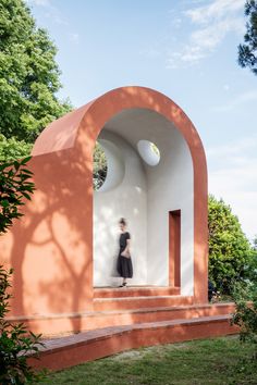 a woman is walking up some steps in front of a building with arches on it