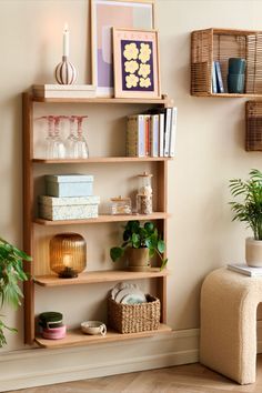 a wooden shelf filled with lots of books next to a chair and potted plant