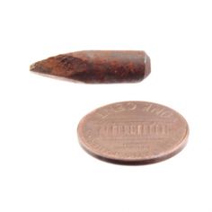 a penny and a piece of metal on a white background