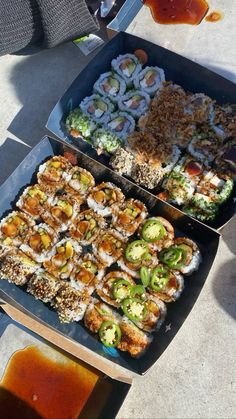 there are many different types of sushi in the trays on the table, including broccoli and cauliflower