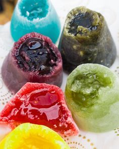 four different colored candies on a white doily