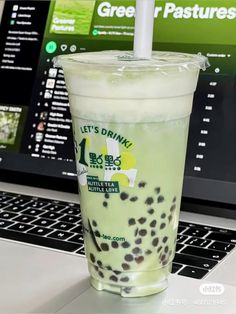 a drink sitting on top of a laptop computer