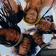 a group of young women standing next to each other looking up at the camera with their heads together