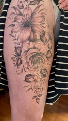 a woman's thigh with flowers and leaves on the side, in black and white