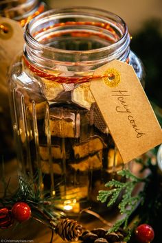 a glass jar filled with lots of different types of food and decorations on top of a table