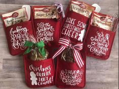 six red bags filled with christmas treats on top of a wooden table