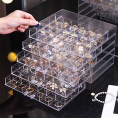 a person holding a pen in front of a display case filled with jewelry