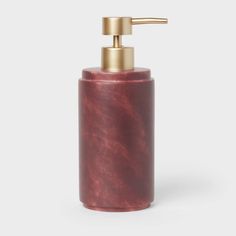 a red soap dispenser on a white background