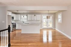 an empty kitchen and living room with hardwood floors