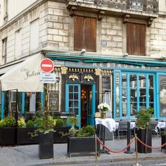 the outside of a restaurant with tables and chairs