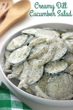 a white bowl filled with sliced up oysters on top of a table next to two wooden spoons