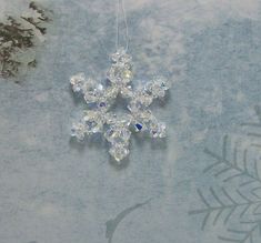 a snowflake ornament hanging from a string on top of a table