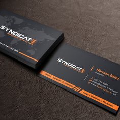 an orange and black business card on top of a brown leather surface with a world map in the background