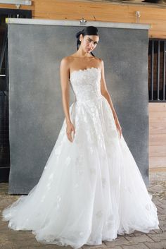 a woman in a white wedding dress posing for the camera