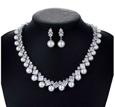 Pearl and CZ Wedding Jewelry Set Complete your elegant wedding day look with our fabulous pearl and CZ necklace and earring set. This glamorous platinum silver plated jewelry set features dazzling AAAAA quality CZ crystals in round and teardrop cuts as well as lustrous pearl beads. This luxurious jewelry set will add timeless elegance to any bridal ensemble. Size: The necklace is about 17" long and the pierced earrings are about 1" long. Color: Silver. Style: ne10130. Please allow about 3 weeks for delivery. Shipping Policy . Return Policy White Gold Pearl Necklace With Cubic Zirconia For Wedding, Luxury Silver Platinum Bridal Necklace, Silver Cubic Zirconia Pearl Necklace For Parties, Silver Cubic Zirconia Pearl Necklace For Wedding, Silver Pearl Wedding Jewelry Sets, Anniversary Jewelry Sets With Pearl Drop And Cubic Zirconia, Silver Pearl Jewelry Sets With Pearl Chain, Formal Silver Pearl Bridal Sets, Elegant Silver Pearl Jewelry Sets