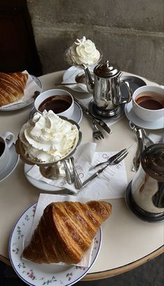 a table topped with pastries and cups of coffee