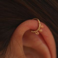 a woman's ear is shown with a gold cartilage