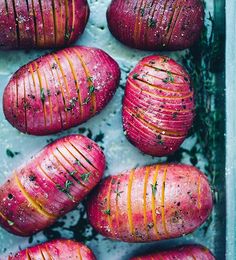 freshly baked red potatoes in a baking dish with herbs on top, ready to be cooked