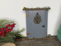 there is a small door on the shelf next to some christmas trees and ornaments in front of it