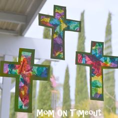 three stained glass crosses hanging from the side of a window