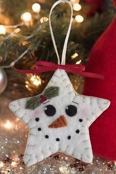 an ornament shaped like a snowman hanging from a christmas tree