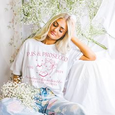 a beautiful blonde woman sitting on top of a bed next to baby's breath flowers