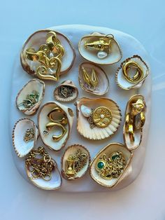 a white plate topped with lots of different types of rings and brooches on top of each other