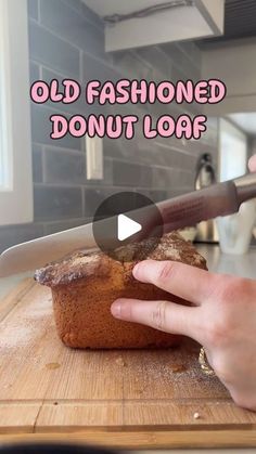 someone is cutting up a loaf of bread on a cutting board with the words old fashioned donut loaf